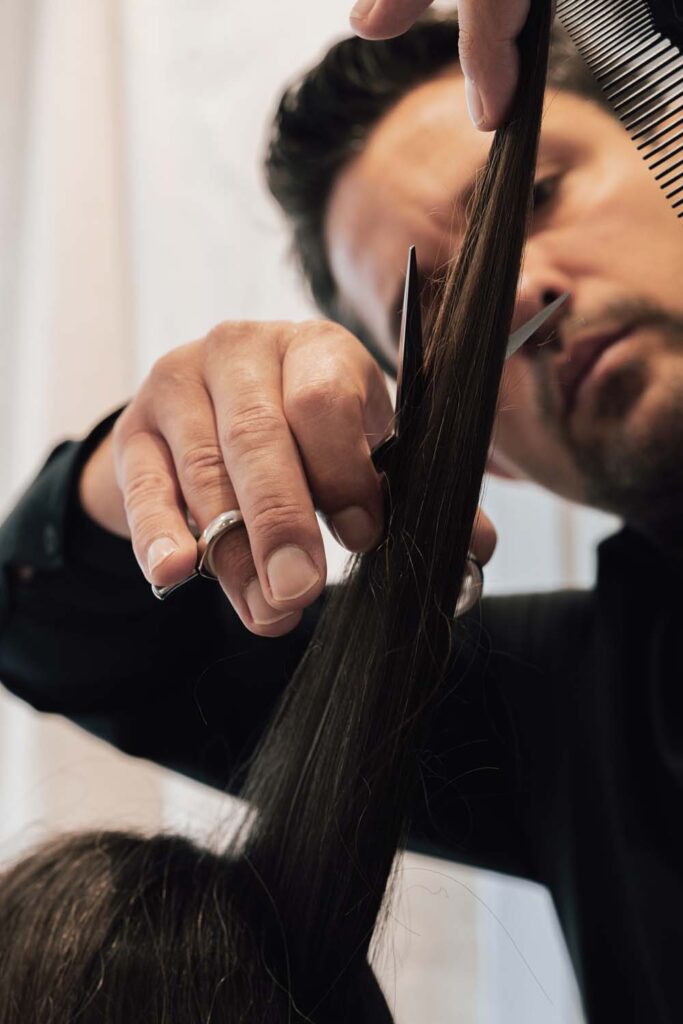 Close-up of a hairdresser cutting a client's hair with scissors at Rossano Ferretti HairSpa.