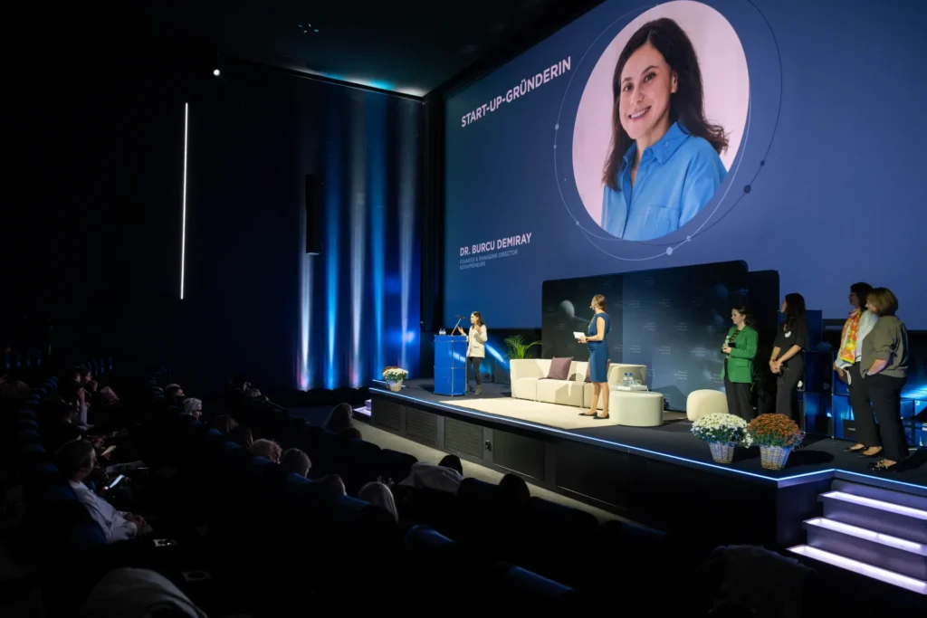 Dr. Burcu Demiray präsentiert Novapreneurs auf der Bühne des Female Innovation Forum 2026 im blue Cinema Abaton in Zürich.