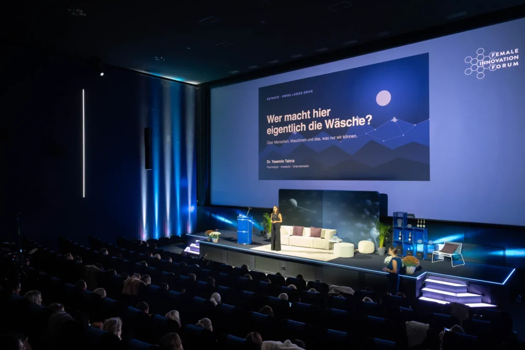 Dr. Yasemin Tahris, Co-Founder von Flowit, hält ihre Keynote auf der Bühne des Female Innovation Forum 2026 vor dem Publikum im Kinosaal.