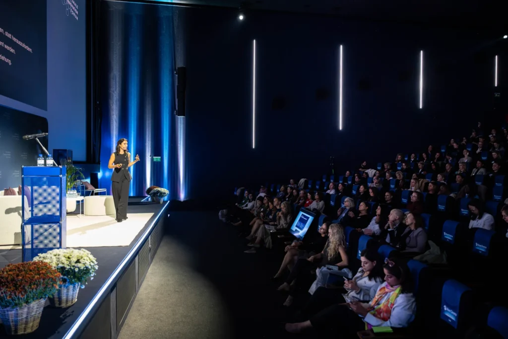 Dr. Yasemin Tahris, Co-Founder von Flowit, hält ihre Keynote auf der Bühne des Female Innovation Forum 2026 vor dem Publikum im Kinosaal.